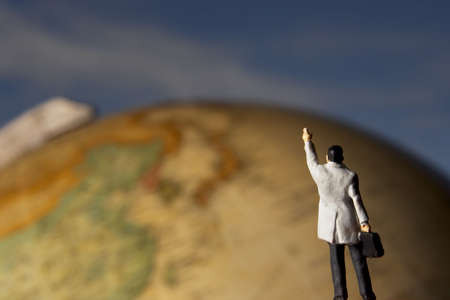 Business figurine placed next to globe.の写真素材