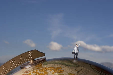 Business figurine placed on antique earth globe.の写真素材