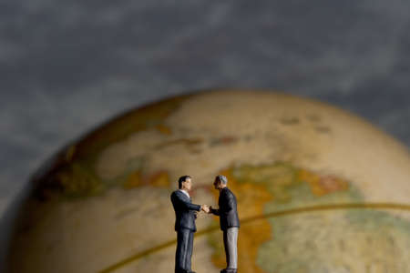 Business figurine placed with antique earth globe.の写真素材