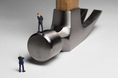Building a business: Business figurines place with a hammer.の写真素材