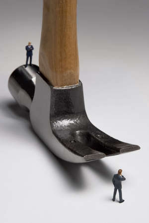 Building a business: Business figurines place with a hammer.の写真素材