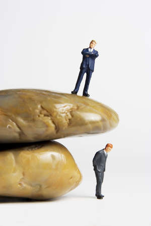 Business figurine placed next to rocksの写真素材