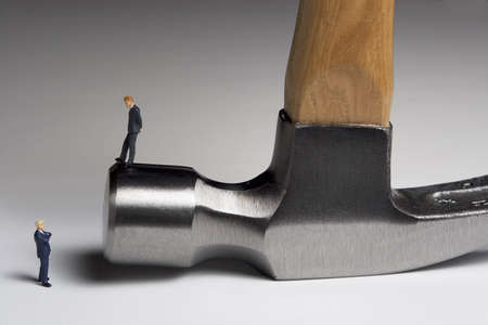 Business figurines placed on a hammerの写真素材