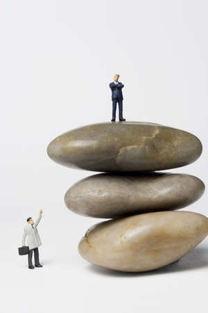 Business figurine placed next to rocksの写真素材