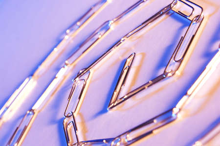 Still life of a chain of paperclips with blue and orange lightingの写真素材