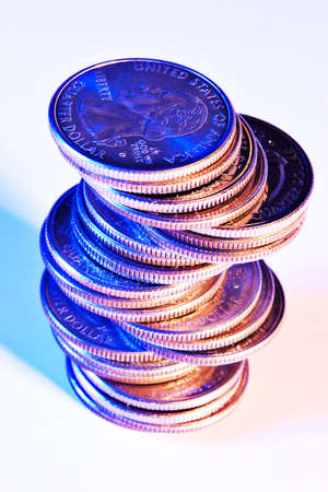 Skewed stack of quarters with blue and orange lightingの写真素材