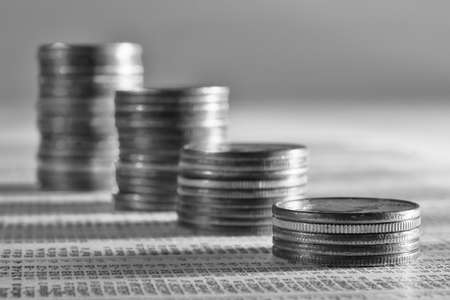 Coins stacked as a falling graph on stock reportの写真素材