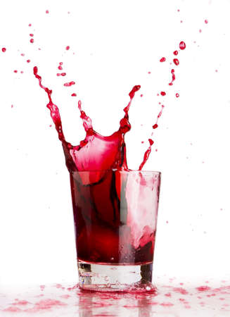 Ice cube dropped into a glass of grape juice の写真素材