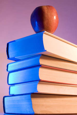 Apple placed on a stack of booksの写真素材