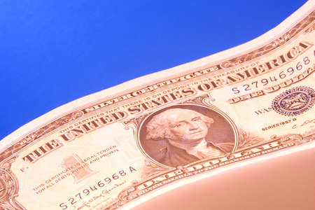 A dollar photographed with orange and blue lighting.
