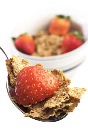 Spoon and bowl of breakfast cereal with strawberries