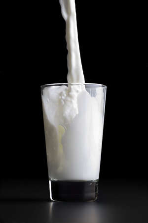 Pouring a glass of milkの写真素材