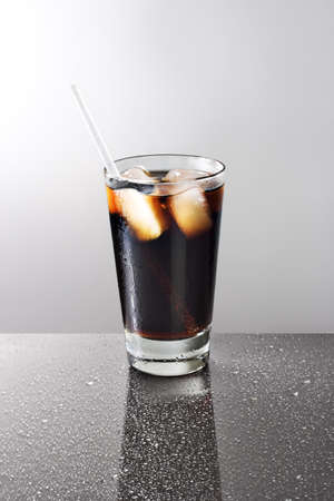 Glass of soda on a wet reflective table