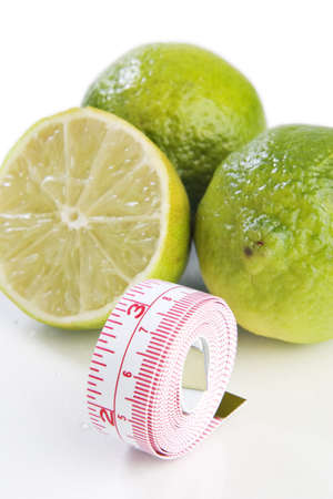 Lemons with a tape measure on white の写真素材