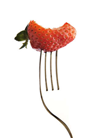 Strawberry with a bite out of it on a fork. の写真素材