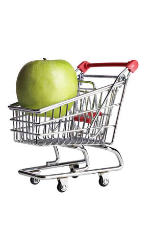 A green apple in a miniature shopping cart on white.の写真素材