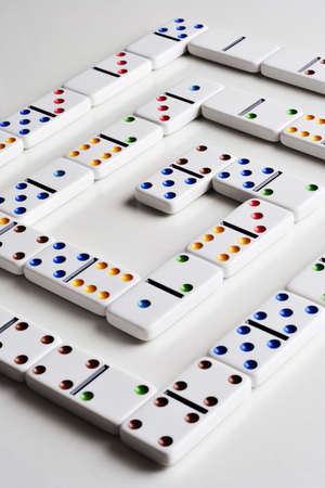 Dominos placed in a spiral pattern on a white tabletop の写真素材