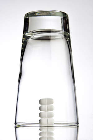 Glass placed on top of white pills の写真素材