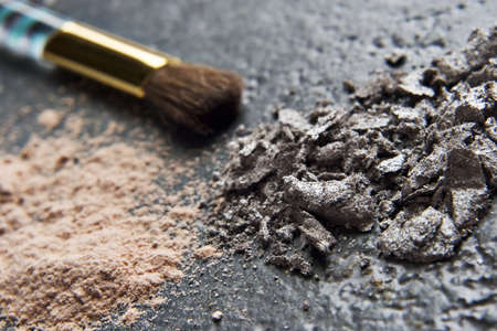 Powder makeup and brush placed on a granite tabletop の写真素材