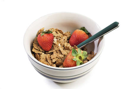 Spoon and bowl of breakfast cereal with strawberries