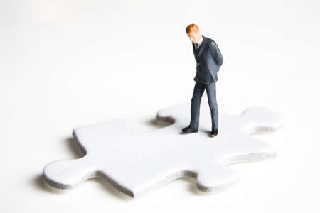 Businessmen figurines standing on a puzzle pieceの写真素材