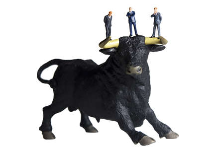 Business figurines placed with bull figurines.の写真素材