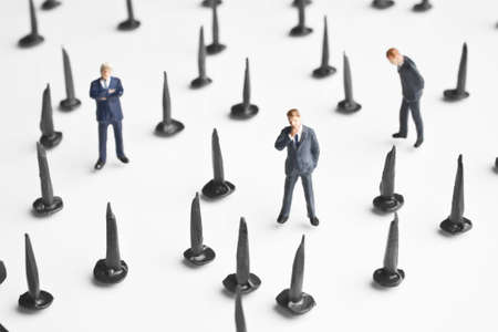 Businessmen figurines placed with tacks の写真素材