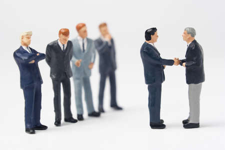 Two business figurines shaking hands の写真素材