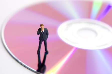 Business figurine standing on a compact diskの写真素材