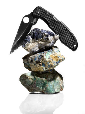 Black knife balanced on a stack of exotic rocks.の写真素材