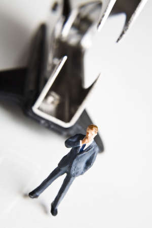 Businessman figurines standing next to a staple removerの写真素材