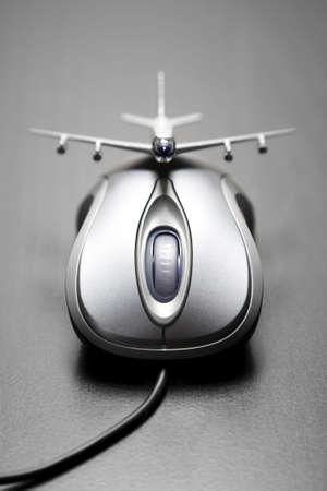 Toy airplane placed on a computer mouseの写真素材