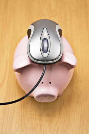 Metallic mouse placed on a piggy bankの写真素材