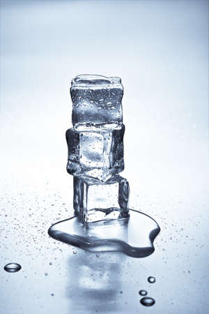 Melting ice cubes on a metal tabletopの写真素材