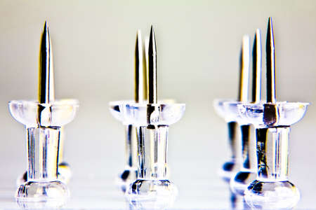 Rows of thumbtacks placed on a white tabletop の写真素材