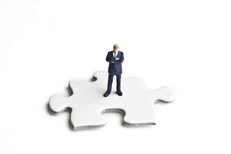 Businessman figurines placed with puzzle piecesの写真素材