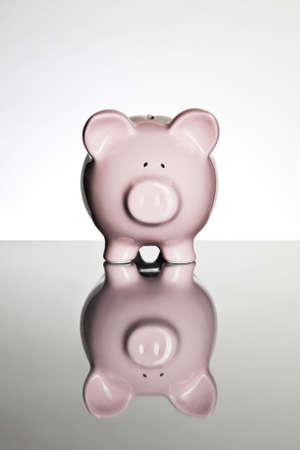 Piggy bank on a reflective tabletopの写真素材