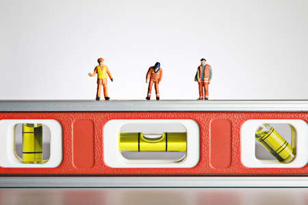 Worker figurines placed on a levelの写真素材