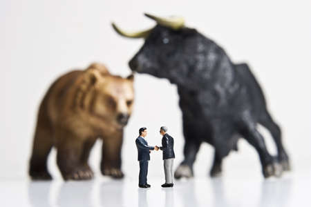Business figurines placed with bull and bear figurines.の写真素材