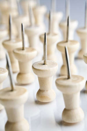 Rows of thumbtacks placed on a white tabletop の写真素材