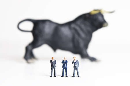 Business figurines placed with a bull figurine.の写真素材