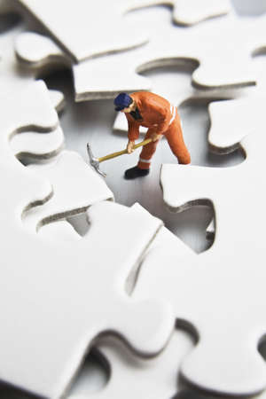 Worker figurines placed with puzzle piecesの写真素材
