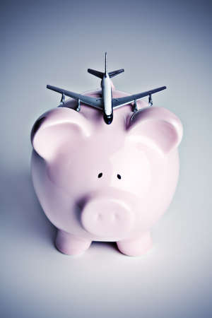 Piggy bank with toy airplaneの写真素材