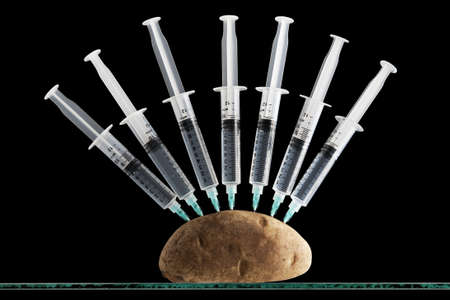 Syringes stuck in a potato の写真素材