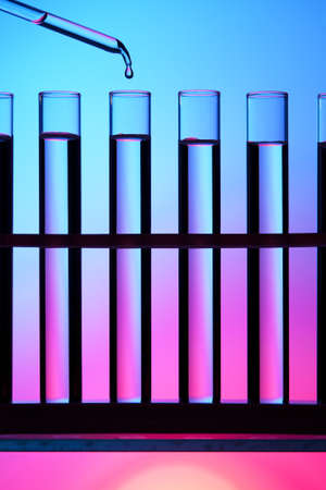Test tubes and dropper against a colorful background 