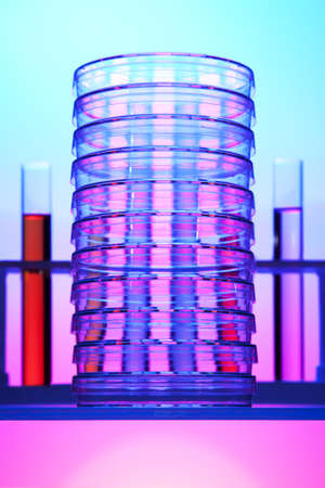 Stack of petri dishes in front of test tubes の写真素材
