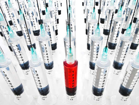 Rows of syringes, one filled with blood の写真素材