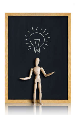 Manikin, anatomical model, placed on a chalkboard with a lightbulb drawn on it の写真素材
