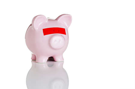 Piggy bank with red tape over its eyesの写真素材