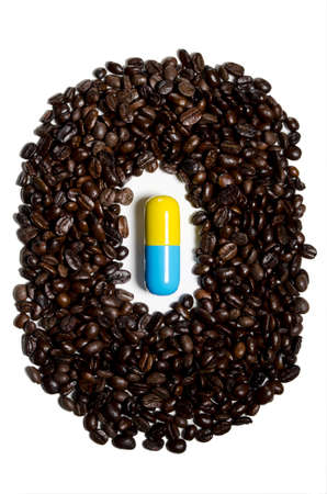 Pill surrounded by coffee beansの写真素材